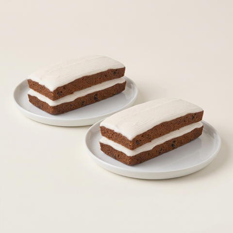 Two rectangular Spanish Bar Cakes with white icing, displayed side by side on white plates against a neutral background